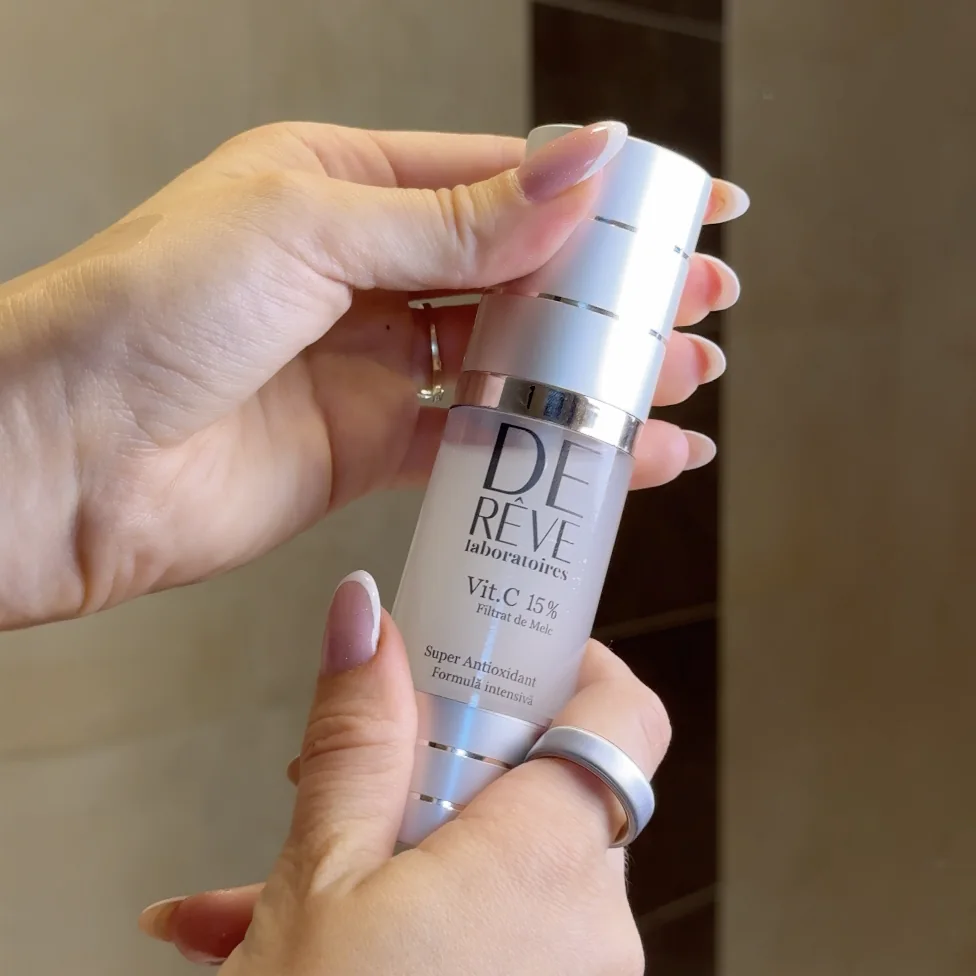 Serul cu Vitamina C 15% De Rêve, flacon airless de 30 ml, ținut în mână